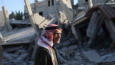 Người đàn ông Palestine trước đống đổ nát ở dải Gaza.